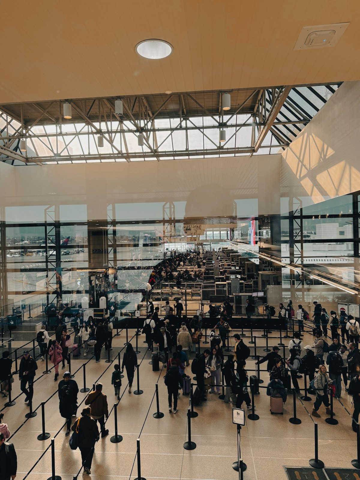 Travelers moving through a crowded airport terminal during peak travel season